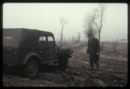 Deux hommes examinant une voiture embourbée au bord d'un champ (nord-est de la Hongrie)