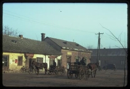 Rue de village, échoppes, charrettes tirées par des chevaux (nord-est de la Hongrie)